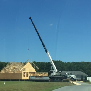 White Sussex Crane Company Truck moving house frame down