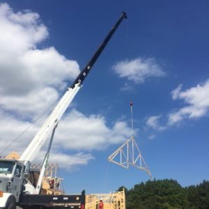 White Sussex Crane hoisting second house frame piece